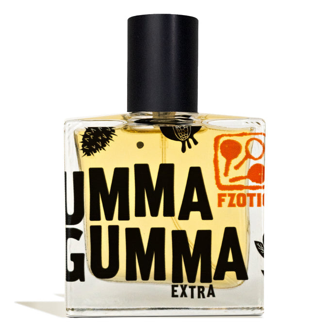 Ummagumma Extra EDP by Fzotic comes in a square glass bottle labeled "UMMA GUMMA EXTRA" with black and orange accents, a black cap, and light yellow liquid. It offers a smoky gourmand fragrance with notes of dark chocolate.