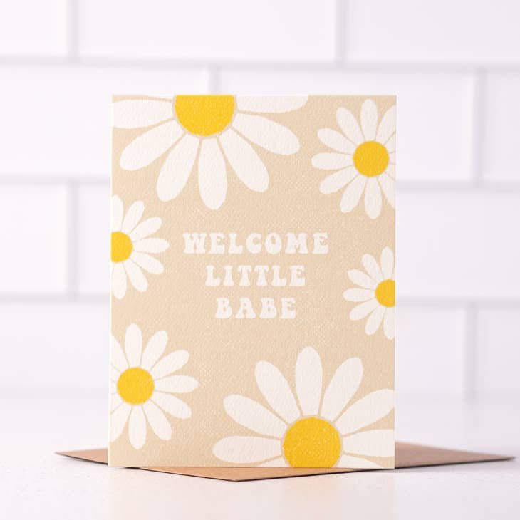 Welcome Little Babe | Daydream Prints card by Daydream Prints features big white and yellow daisies with "Welcome Little Babe" on the front, paired with a brown envelope—a perfect boho welcome baby card.