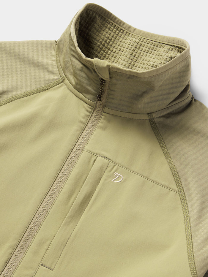 Close-up of Duck Camp’s W's Lightweight Grid Tech Fleece Half Zip in Sagebrush, featuring a high collar, chest pocket, textured panels, and subtle logo—making it the perfect lightweight midlayer.