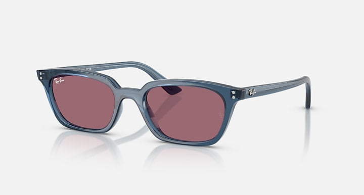 Ray-Ban Zaya sunglasses feature light blue frames and violet-tinted square lenses, shown against a plain white background.