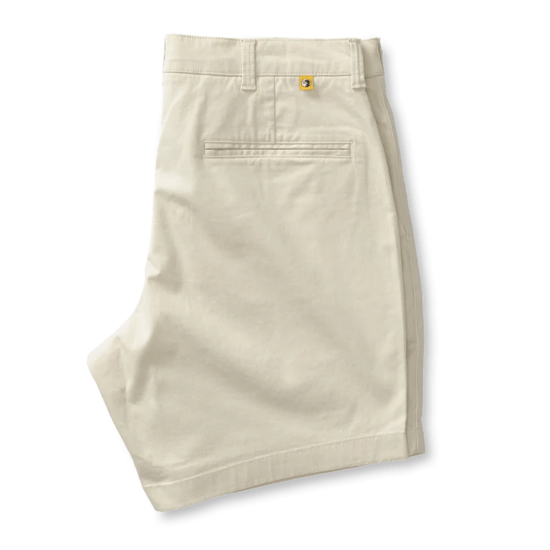 A pair of Duck Head 7 in Gold School men's chino shorts with belt loops, a single back pocket, and a small yellow logo above the pocket is displayed on a white background.