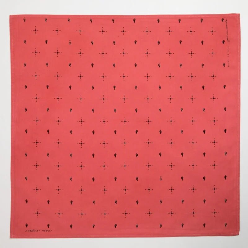The Jenni Earle Bandana | Explore More is a square, hand-dyed red cotton bandana featuring a minimalist pattern of evenly spaced black dots and small symbols.