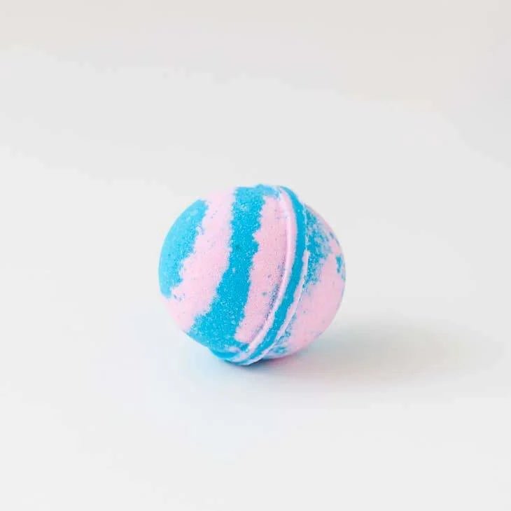 The Old Whaling Co. Bath Bomb in Cotton Candy features blue and pink swirled stripes, resembling cotton candy, and is displayed on a white surface.