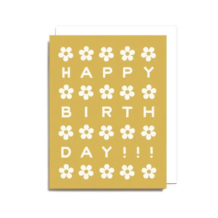 The Birthday Daisies Card by Worthwhile Paper is a yellow recycled paper card with white daisy patterns and bold “HAPPY BIRTHDAY!!!” text in a grid design.