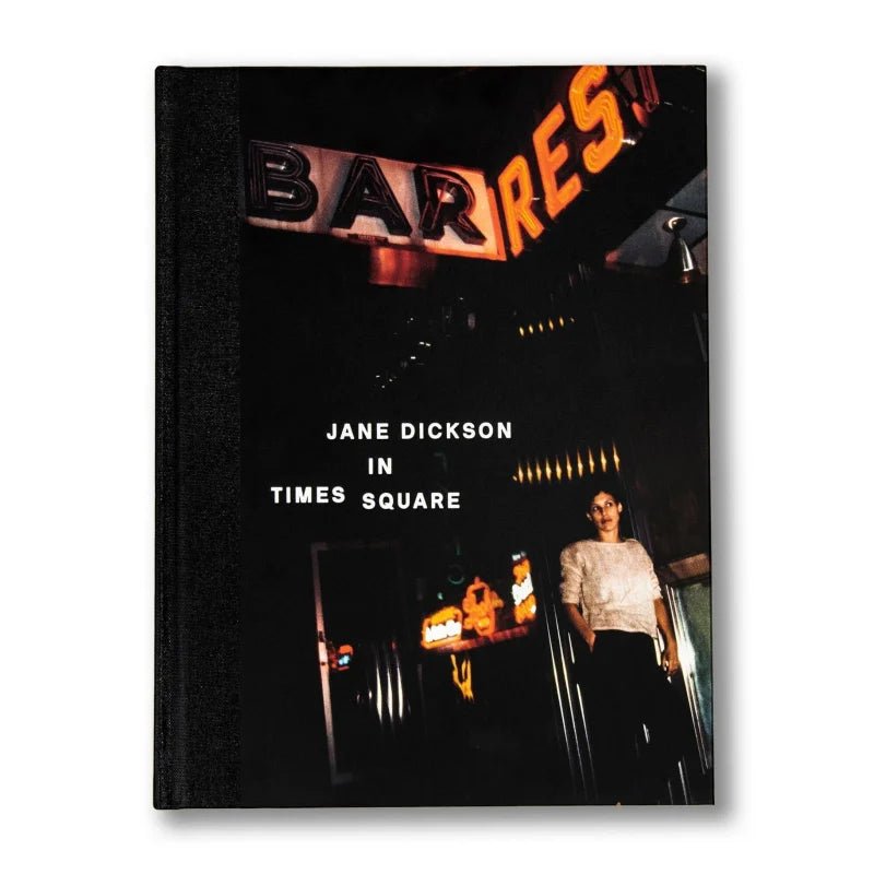 The cover of Anthology Editions’ "Jane Dickson in Times Square" depicts a woman beneath glowing neon "BAR" and "RES" signs, reflecting the vivid New York City art scene.