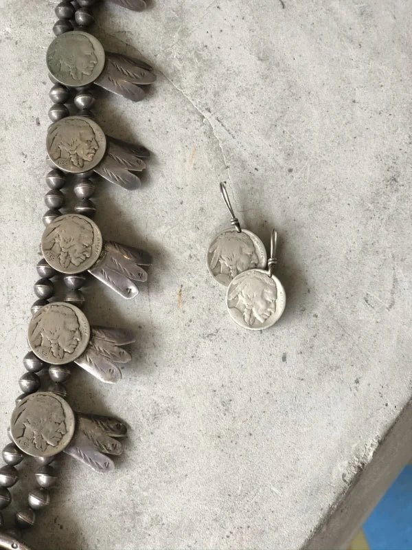 The Buffalo Nickel Squash Blossom necklace and earrings by Vintage are displayed on concrete, showcasing timeless Native American artistry.