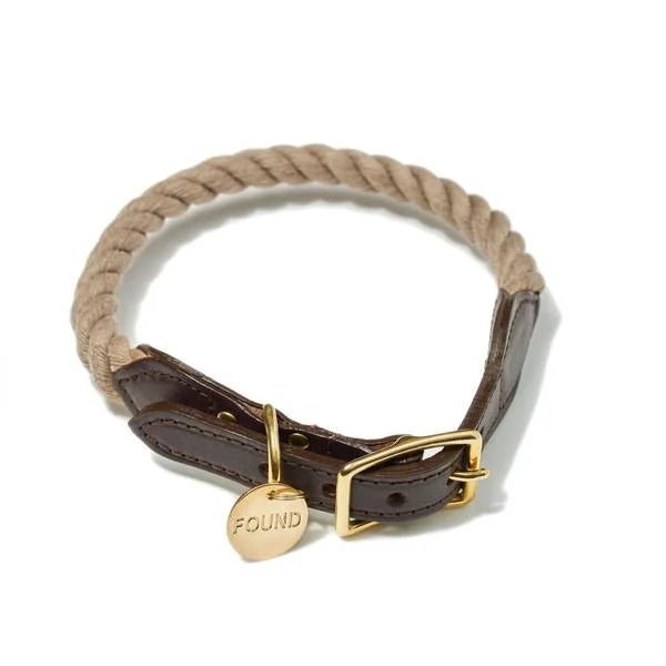 The Found My Animal Collar features tan rope and brown leather, handmade with a gold buckle and an engraved gold "FOUND" tag.