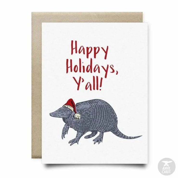 The Happy Holidays Y'all Card by Anvil Cards features an armadillo in a Santa hat with "Happy Holidays, Y'all!!" on linen paper. This A2 card is blank inside for your own message.