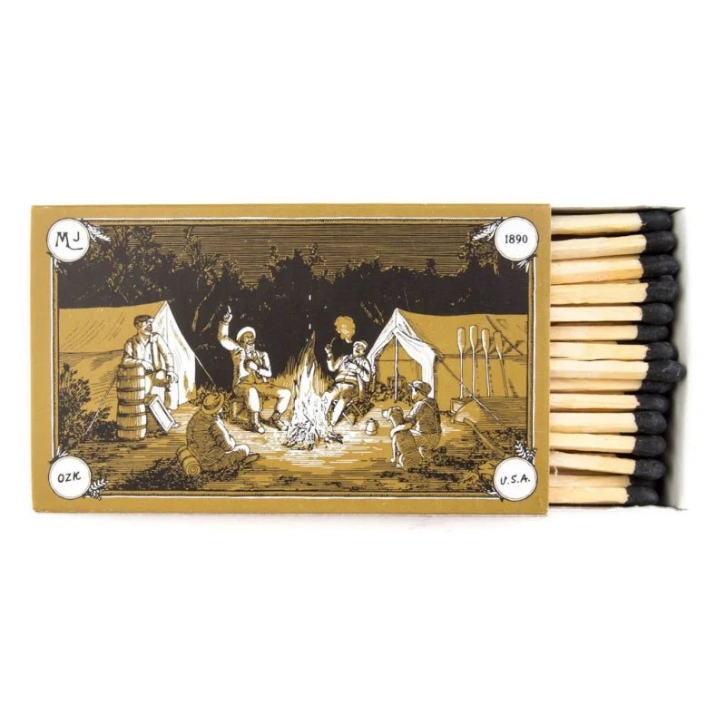 The MJ 4" Hearth Safety Matches by Mollyjogger feature a vintage illustration of campers around a campfire with tents and supplies—an ideal collectible for any Mollyjogger fan.