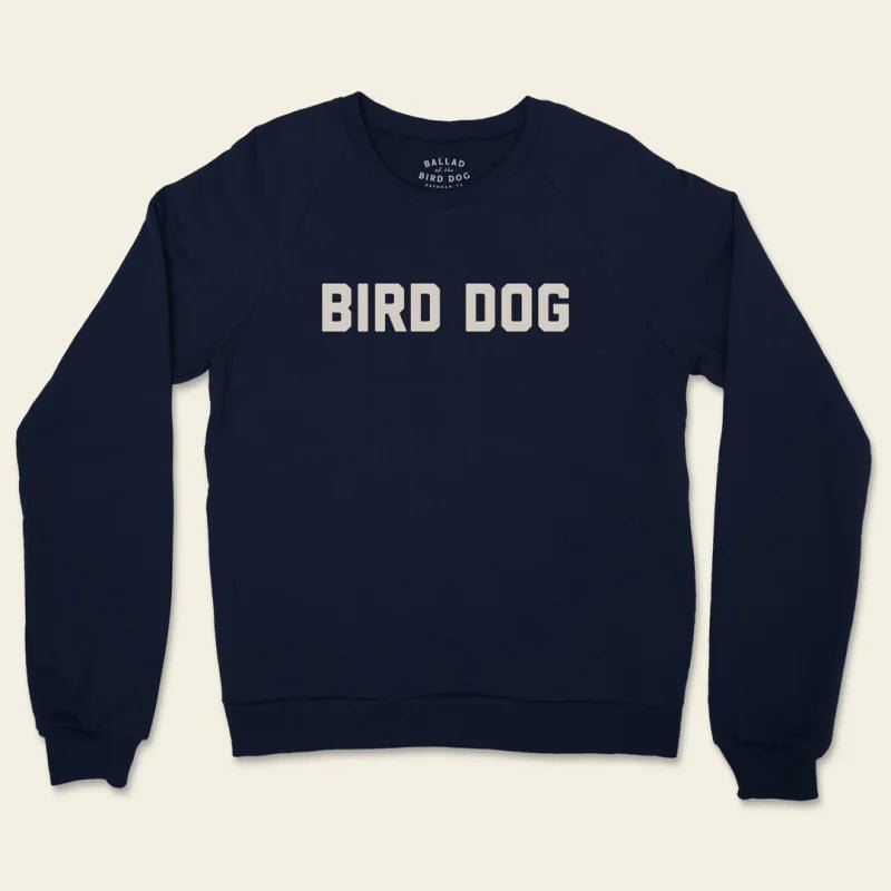 The Ballad of the Bird Dog "Shop Sweater" is a navy unisex crewneck with "BIRD DOG" in bold white letters across the chest, made in the USA for comfort and style.