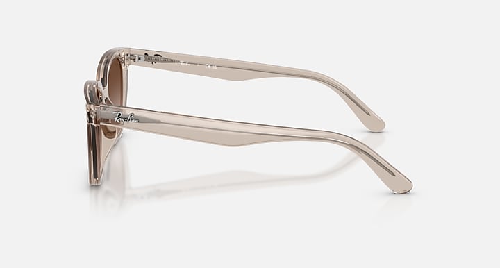 Side view of translucent beige Ray-Ban RB2243D sunglasses with brown gradient lenses.