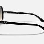 The Ray-Ban RB4125 sunglasses are featured from a side angle, highlighting the iconic brand logo on both the temple and inside arm. These sunglasses showcase a polished black frame with light grey gradient lenses, set against a plain white background for a modern look.