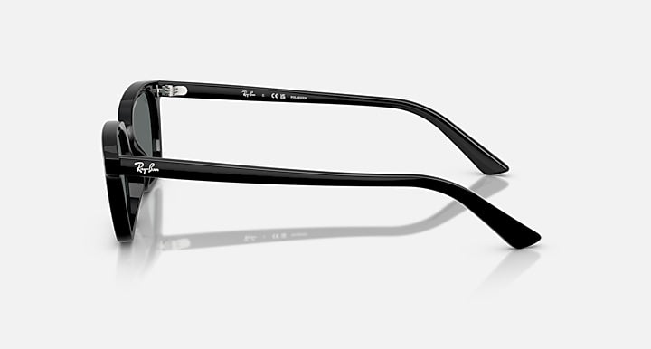 Zaya RB4456F sunglasses by Ray-Ban shown in a side profile on a white background, highlighting the Ray-Ban logo on both the temple and temple tip. These sunglasses feature a sleek black injected frame paired with polarized dark grey lenses, offering a modern and sophisticated aesthetic.