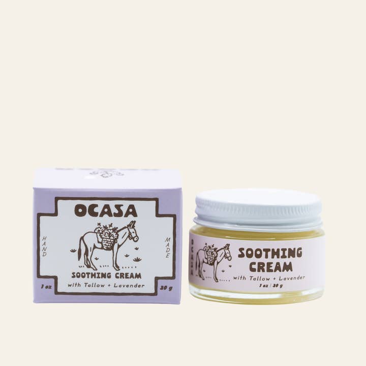 A square box and small glass jar of Lavender Tallow Face Cream | OCASA, featuring an illustration of a donkey carrying a basket of flowers for sensitive skin.
