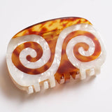 Large oval Twin Spiral Claw hair clip by Winona Irene featuring a white and brown tortoiseshell spiral design.