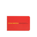 The Field Notes 1943 Two-way Memo Book, inspired by Armed Services Editions, features a red cover with yellow text and is shown closed with the spine visible on the left.