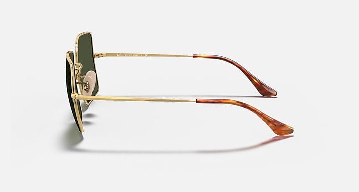 Side view of Ray-Ban 1971 Square sunglasses featuring green lenses, oversize square polished Arista gold metal frames, and brown tortoiseshell temple tips, displayed on a light gray background.