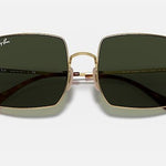 The Ray-Ban 1971 Square sunglasses feature polished Arista gold oversize square metal frames and green lenses, shown against a white background.