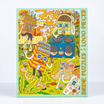 The House Party 1,000 Piece Puzzle by Birdie Puzzles features whimsical cartoon houses with faces and arms. Made from recycled materials, it's perfect for puzzle nights. Box text reads “Birdie Puzzles 1,000 Pieces.”.