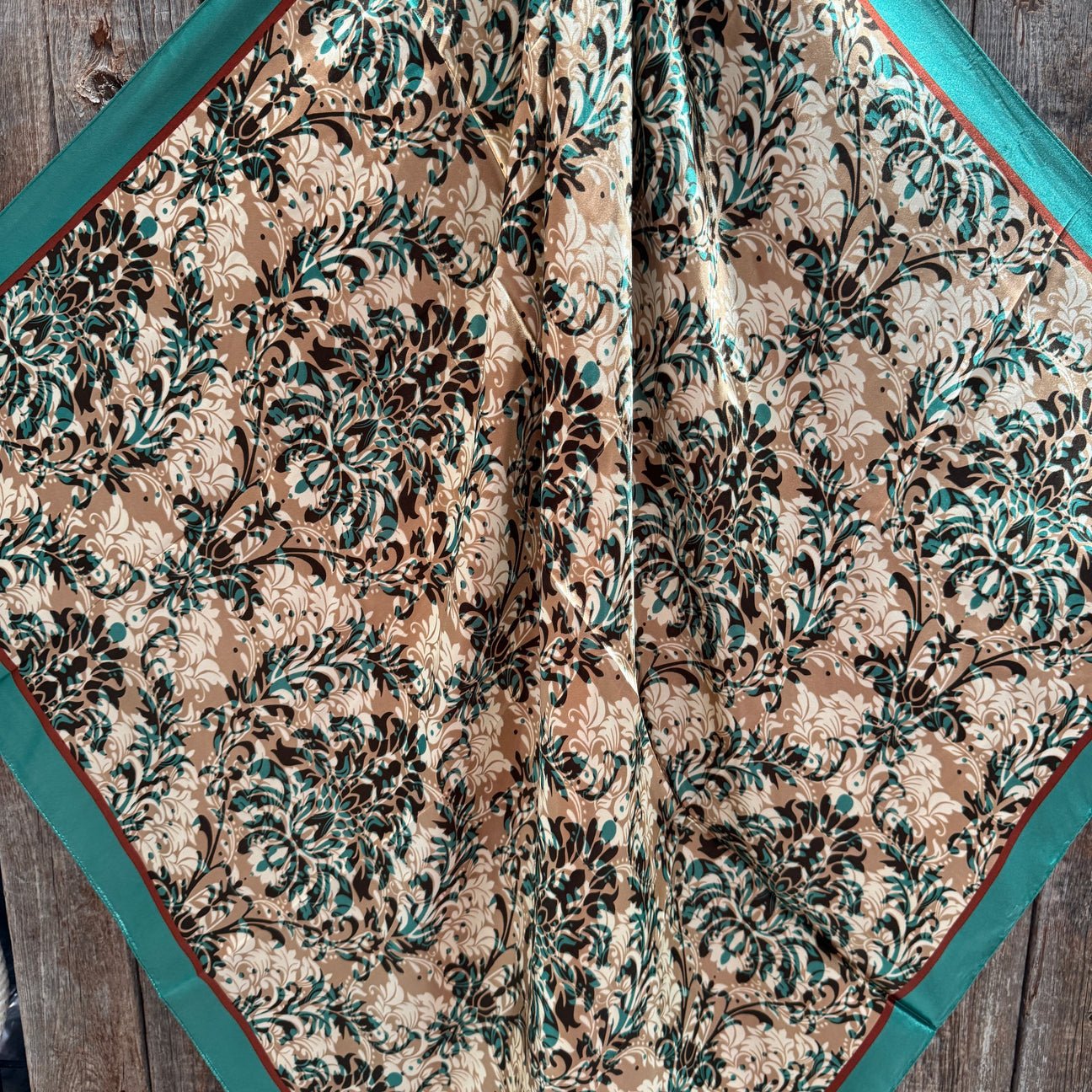 The Emerald and Tan Floral Wild Rag by Rodeo Drive features a silky square polyester scarf with green and beige floral patterns—an elegant western accent for any outfit.