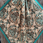 The Emerald and Tan Floral Wild Rag by Rodeo Drive features a silky square polyester scarf with green and beige floral patterns—an elegant western accent for any outfit.