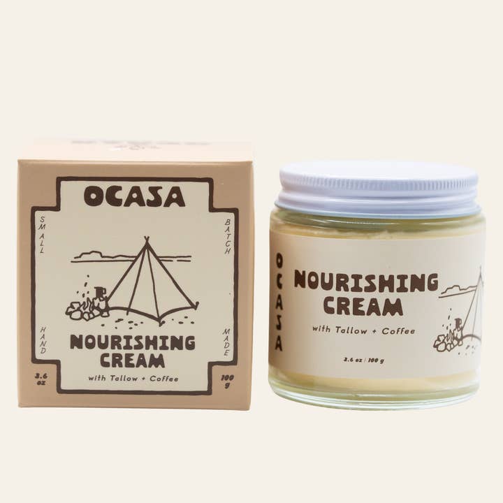 A square box and a glass jar of OCASA Nourishing Coffee-Infused Tallow Cream, both featuring illustrations of a tent and coffee brewing with labels reading “Nourishing Cream with Tallow + Coffee.”