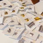 Silver Gladiator Rings by Ornamental Things, featuring intricate metalwork, displayed on white branded cards and arranged neatly on a flat surface.