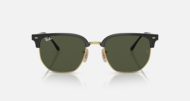 The Ray-Ban 4416 sunglasses feature dark green lenses, a black upper frame with gold detailing, and adjustable nose pads, presented against a plain light background for a timeless minimalist look.