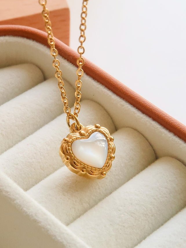 Josie Vintage Heart Pendant Necklace by Flanerie by MAIQ, a gold stainless steel chain with a vintage heart pendant featuring an iridescent white center in an ornate frame.