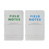 Two Field Notes memo books—one green-labeled "56-Page Ledger Book" and one blue-labeled "56-Week Date Book" from Field Notes—both with white covers and made in the U.S.A.; ideal for your next set of log books.