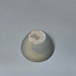 The Stoneware Smudge Bowl by Incausa is a small, hand-thrown ceramic piece with a glossy gray gradient glaze and stamped base, shown upside-down on a plain, light gray surface.
