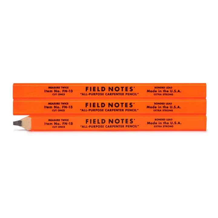 Three unsharpened and one sharpened FSC-certified fluorescent orange Carpenter Pencils from the Field Notes Carpenter Pencil 3-Pack, with the sharpened pencil placed below the others.