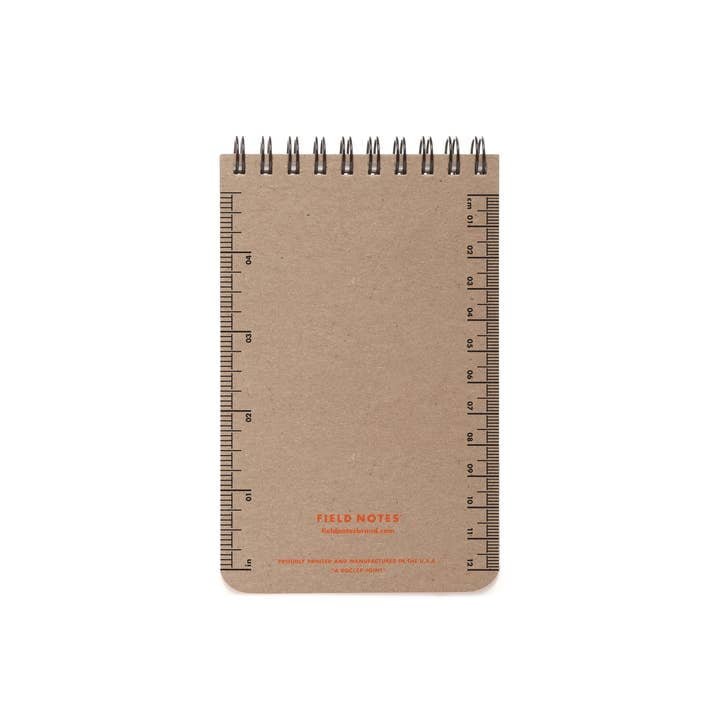The Field Notes 80-Page Work Book is a small spiral-bound notepad with a brown Super Duty Chipboard cover and printed ruler markings along both the left and right edges.
