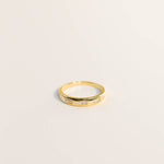 Showcased on a plain light background, the Gold Rings | Inset Baguette by JaxKelly features a series of rectangular baguette gemstones delicately set along the gold band. This hypoallergenic stacking ring from JaxKelly is perfect for everyday wear and makes an elegant addition to any jewelry collection.