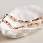 Jolin Bohemian Stone and Bead Bracelet by Flanerie by MAIQ, featuring alternating natural pearls, translucent stones, and 18K gold plated spacers, resting in a white seashell.