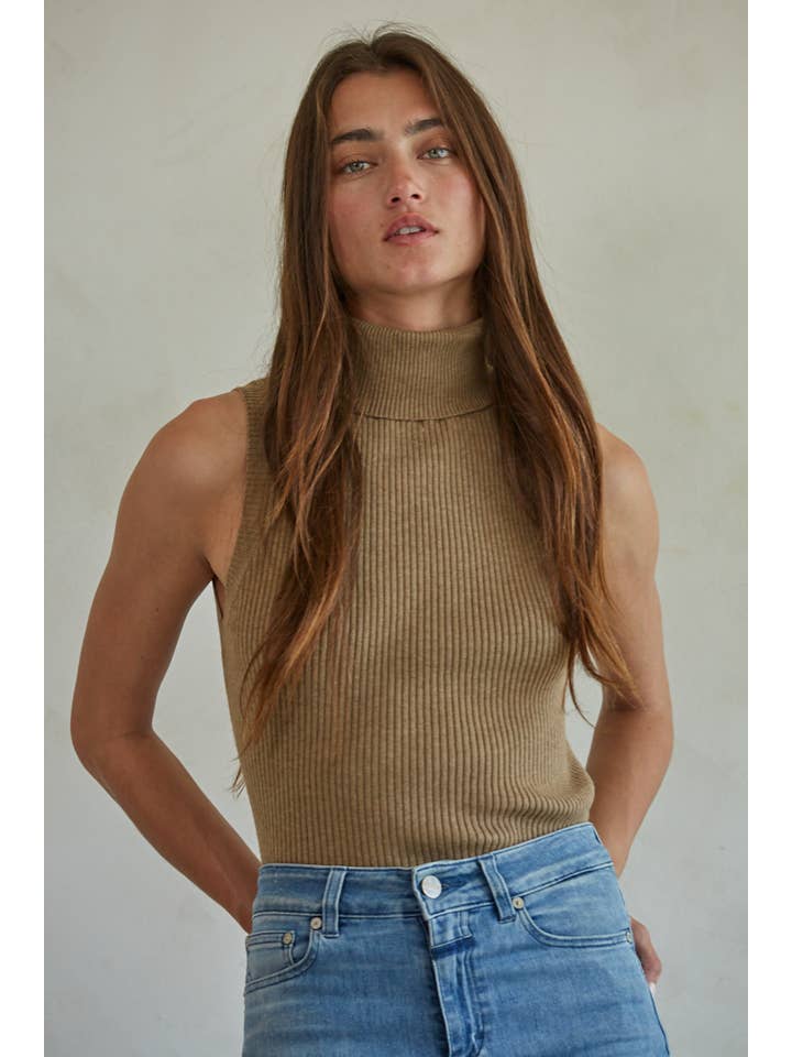 A person wearing a tan Knit Turtleneck Sleeveless Pullover Top in a sleeveless, ribbed turtleneck style.