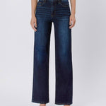 A person models Vervet's 90's Vintage Super High Rise Dark Wash Loose Jeans with a brown top and matching sandals, standing against a plain light background.