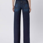 Person wearing Vervet 90's Vintage Super High Rise Dark Wash Loose Jeans and heeled sandals, shown from the back against a plain light background.