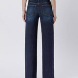 Person wearing Vervet 90's Vintage Super High Rise Dark Wash Loose Jeans and heeled sandals, shown from the back against a plain light background.
