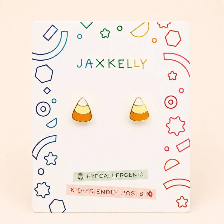 A pair of JaxKelly Candy Corn Enamel Flat Back Earrings displayed on a decorated card, featuring hypoallergenic, kid-friendly posts for sensitive ears.