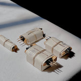 Four Bath & Meditate Bundles by Incausa, each wrapped in white Nepalese Lokta paper and tied with string, are arranged on a white surface in natural light.
