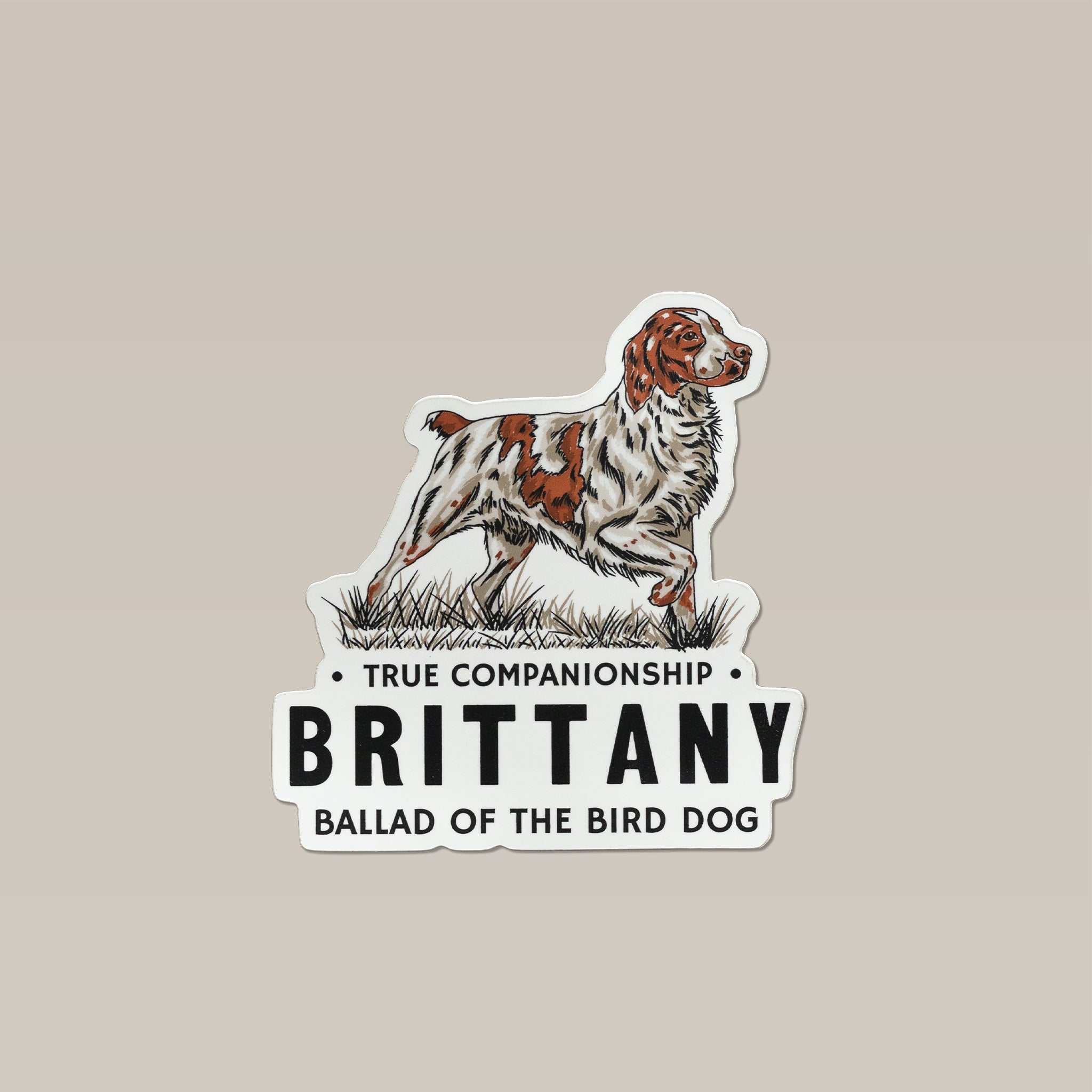 Brittany Spaniel Sticker featuring an embroidered patch illustration of a white and brown Brittany spaniel standing in grass above the text “TRUE COMPANIONSHIP,” “BRITTANY,” and “BALLAD OF THE BIRD DOG.”