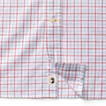 Close-up of a Duck Head Cotton Oxford Sport Shirt in white with red grid pattern, featuring button details and a small person illustration on the inner placket.