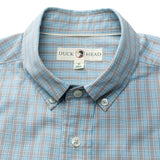 A close-up of the Cotton Cashmere Poplin Sport Shirt by Duck Head in light blue plaid, showing the "Duck Head" label and size M tag inside the collar.
