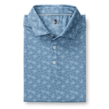 The Duck Head Long Drive Performance Polo in light blue features a subtle duck pattern, three buttons, and moisture-wicking fabric—ideal for comfort on and off the golf course.