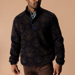 A man wearing a patterned Pineview Fleece 1/4 Snap Pullover over a plaid shirt for lightweight warmth during outdoor activities.