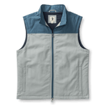 The Duck Head Long Drive Performance vest is sleeveless and zip-up, with a high collar, light gray body, dark blue shoulder yoke, water-repellent fabric, and two side pockets.