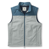 The Duck Head Long Drive Performance vest is sleeveless and zip-up, with a high collar, light gray body, dark blue shoulder yoke, water-repellent fabric, and two side pockets.