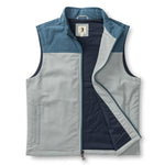 The Duck Head Long Drive Performance vest is a sleeveless zip-up in light gray and blue color blocks with Primaloft insulation, stand collar, open front, water-repellent finish, and two side pockets.