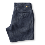 Duck Head Gold School Linen Chino Shorts in navy blue pinstripe feature a back pocket, antique brass button, YKK metal zipper, and a yellow tag above the pocket, shown on a white background.